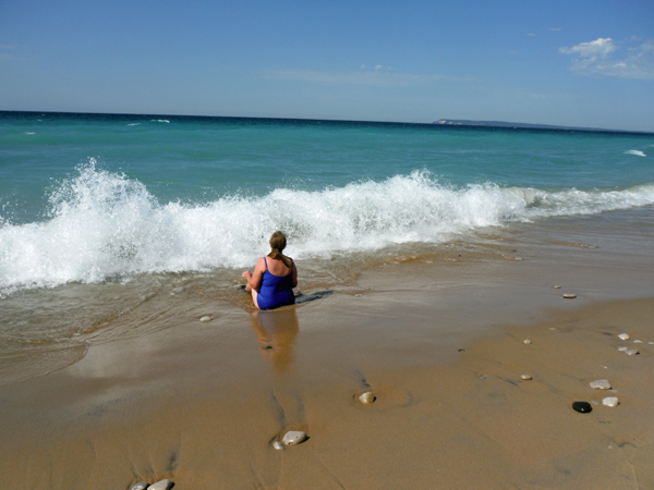 Karen Duquette sits on the shoreline of Lake Michigan